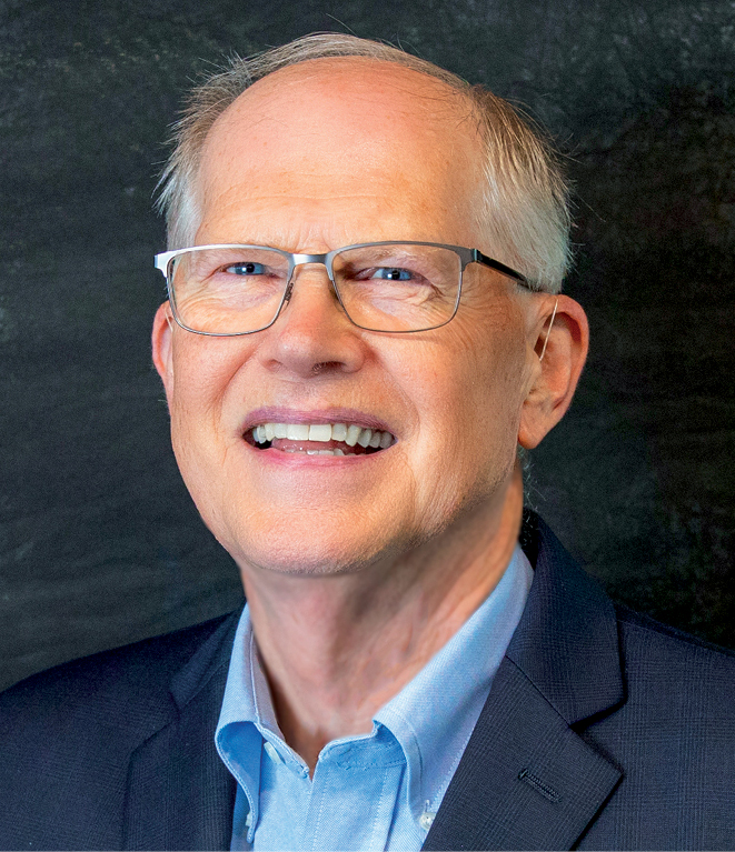 A white man with gray hair wearing glasses and a suit headshot