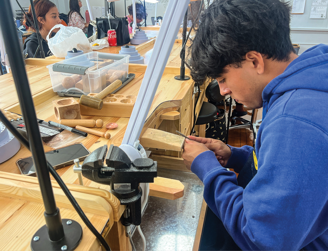 A male student working with wood and tools