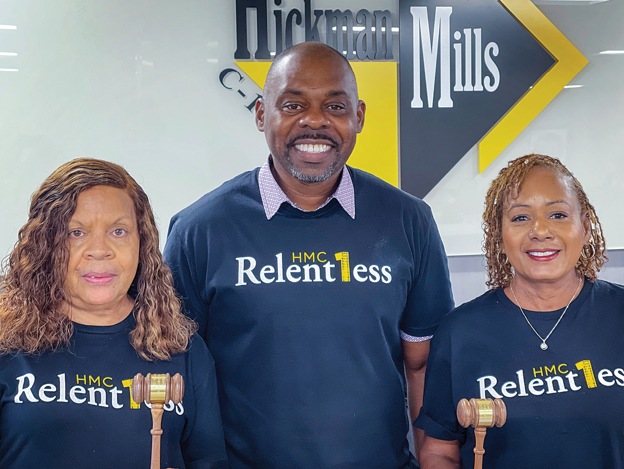 Two women and a man in between them wearing shirts that say 