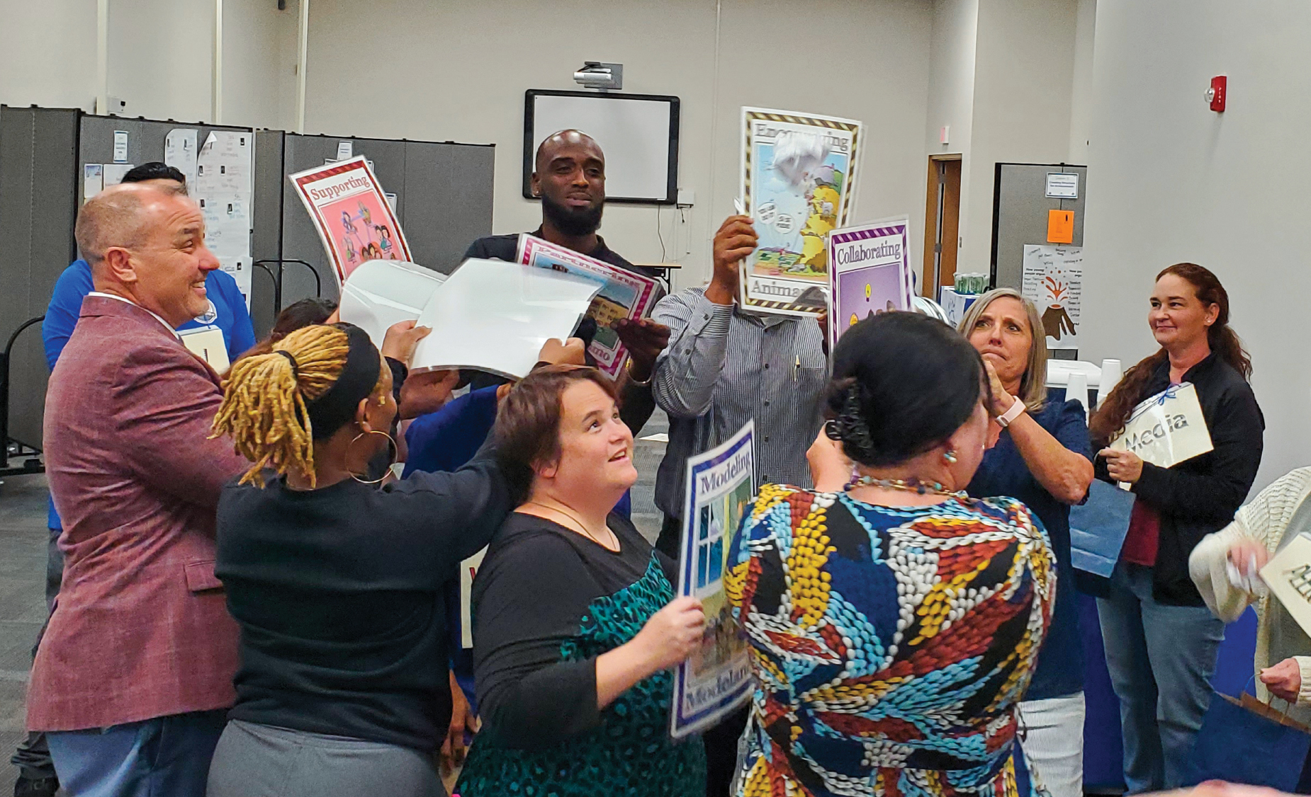 Ken Oerting with a group of staff holding up activity sheets