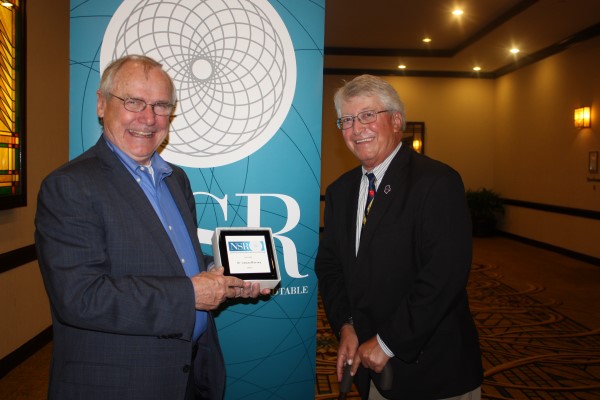 James Harvey poses with an award with a colleague