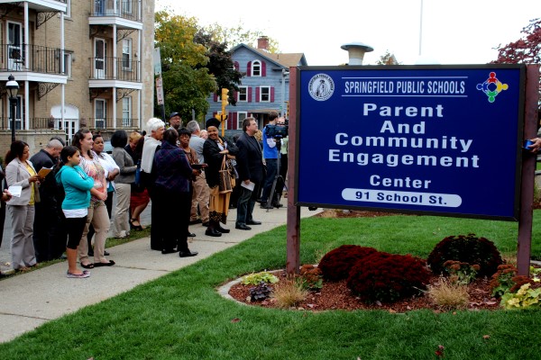 A crowd of people outside  a sign for the Parent and Community Engagement Center