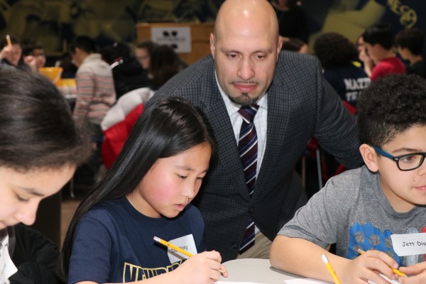 Roberto Padilla leans oversees a student's work