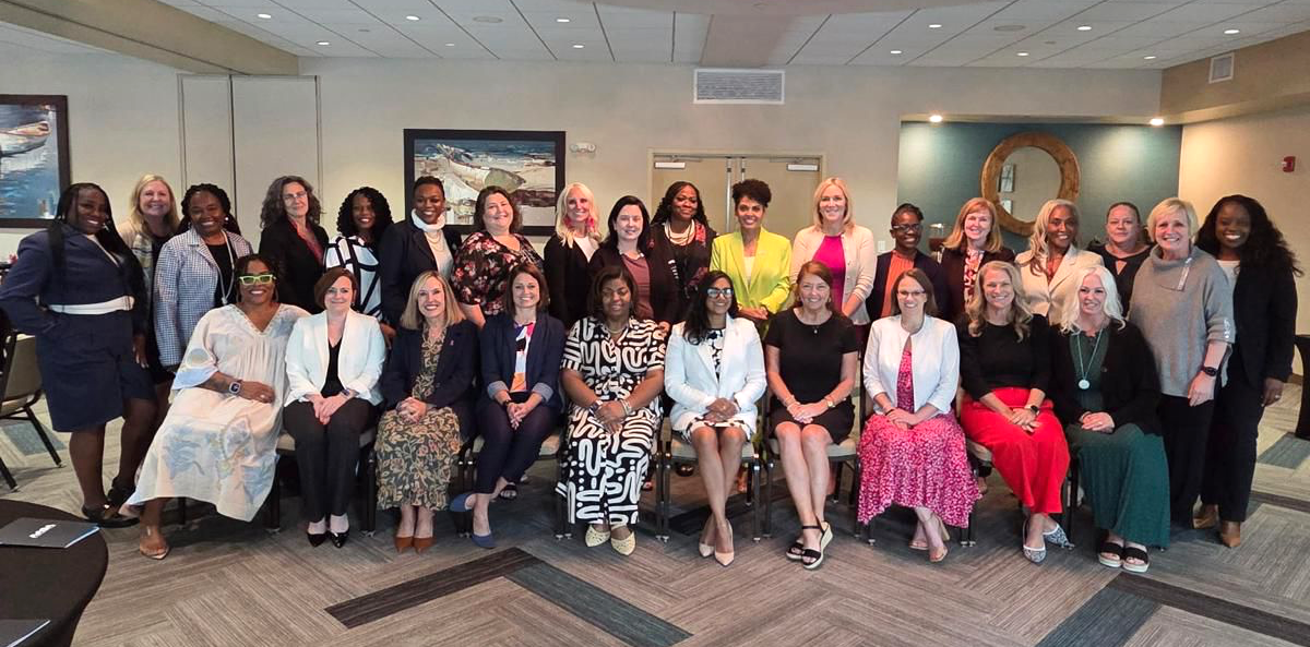 A group photo of 28 women sitting and smiling during the kick off of the AASA Aspiring Superintendents Academy for Women.