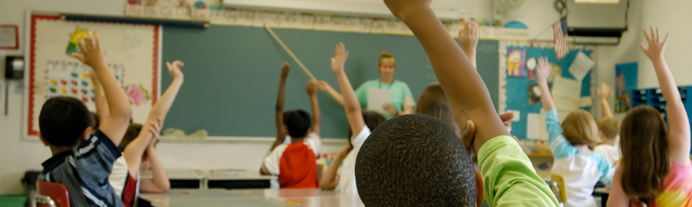 Students with raised hands in a classroom