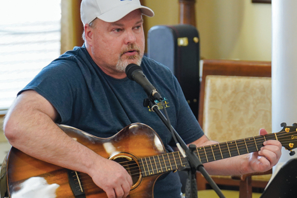 Man at microphone playing guitar