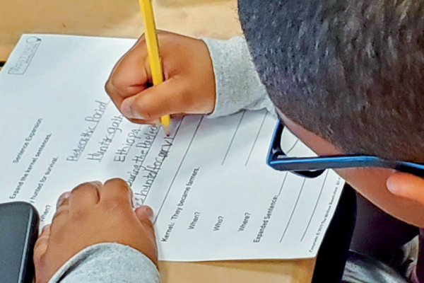 Student writing on piece of paper