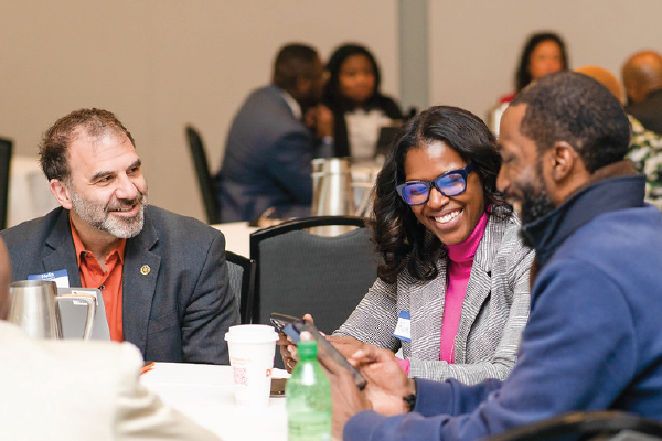 Leaders at a table laughing