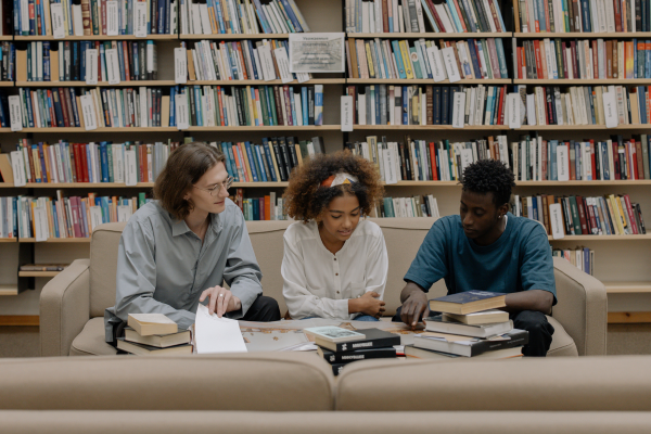 image of three teens reading in a library