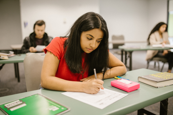 Student writing at desk